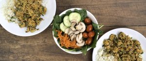 A table set with two plates of Tofu Curry and a veggie salad