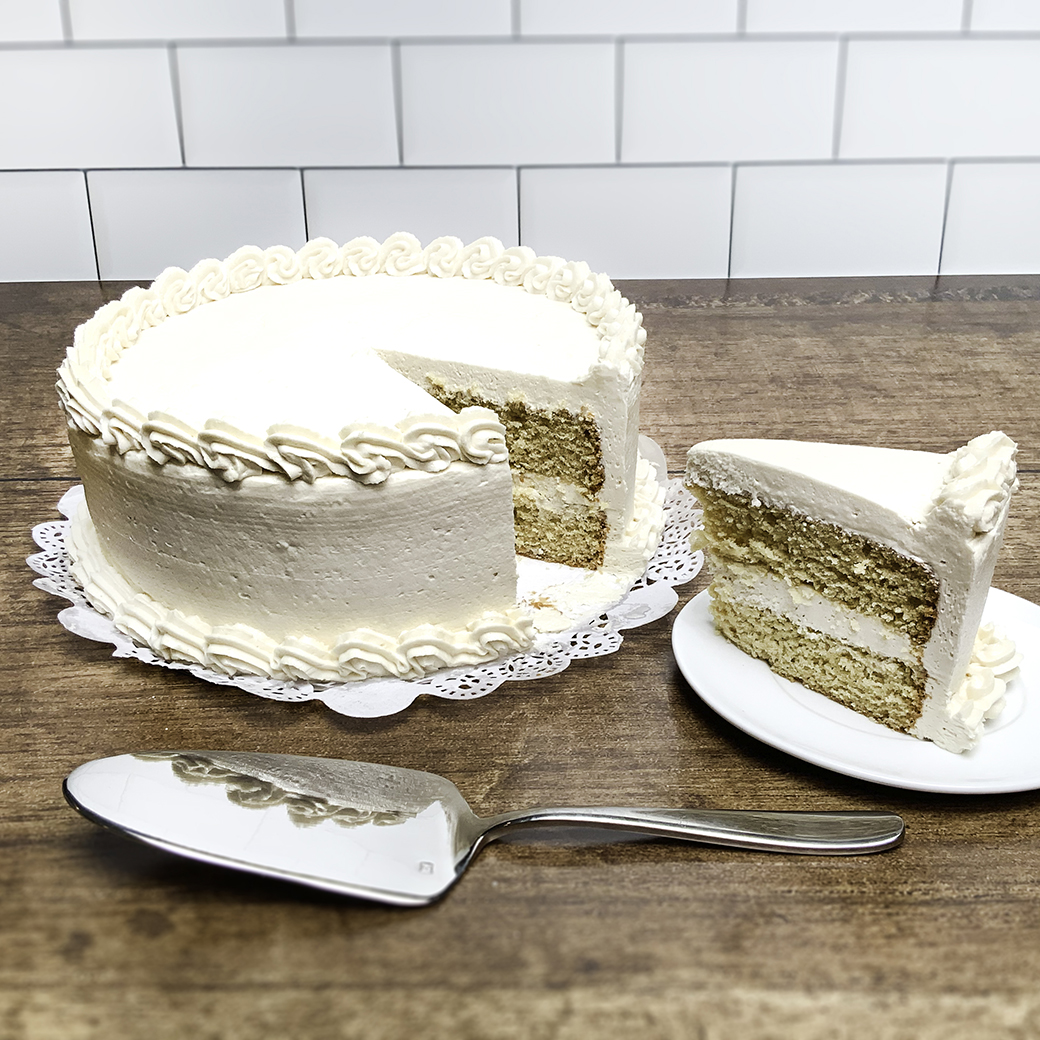 A round, two-tiered vanilla cake with beautiful vanilla frosting