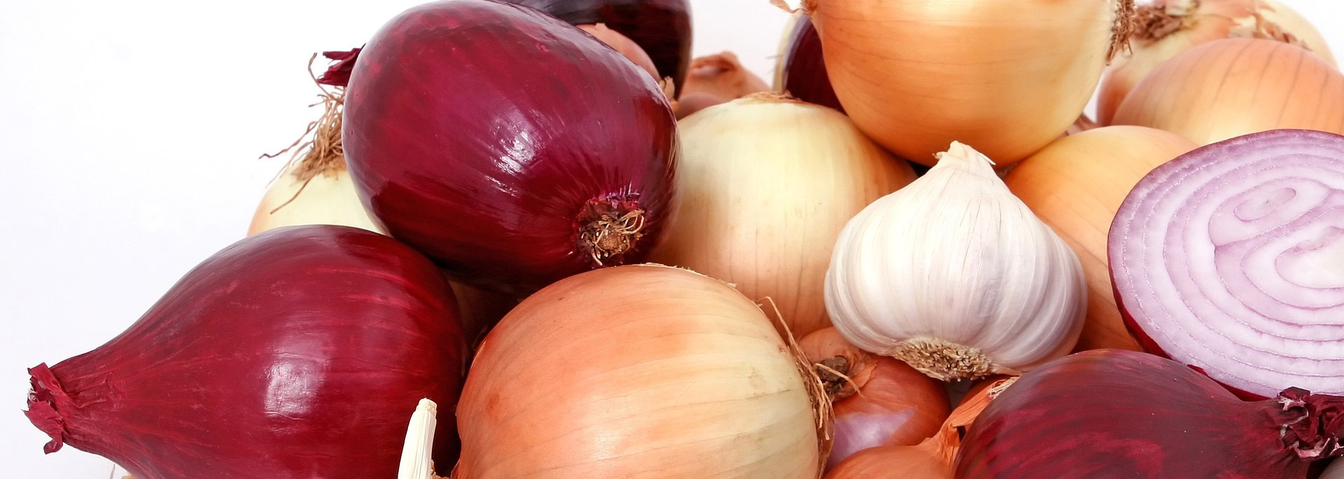 A pile of different kinds of onions and garlic