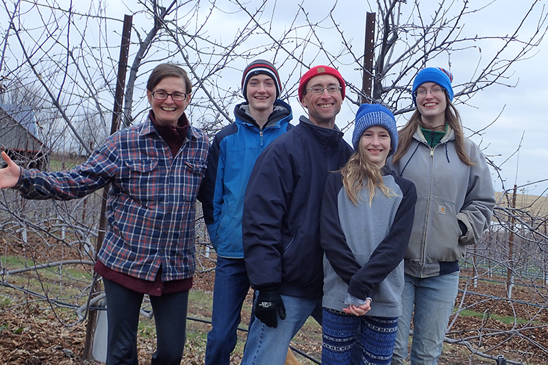 The McGuire Family of Two Onion Farm standing in front of some trees in winter