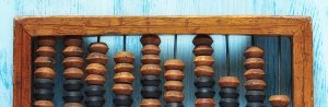 Old wooden scratched vintage decimal abacus on a blue wooden board for the background. Flat lay.