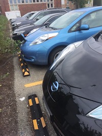 Cars in a parking lot, two electric cars charging