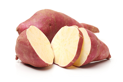 Two Japanese sweet potatoes, one of them sliced