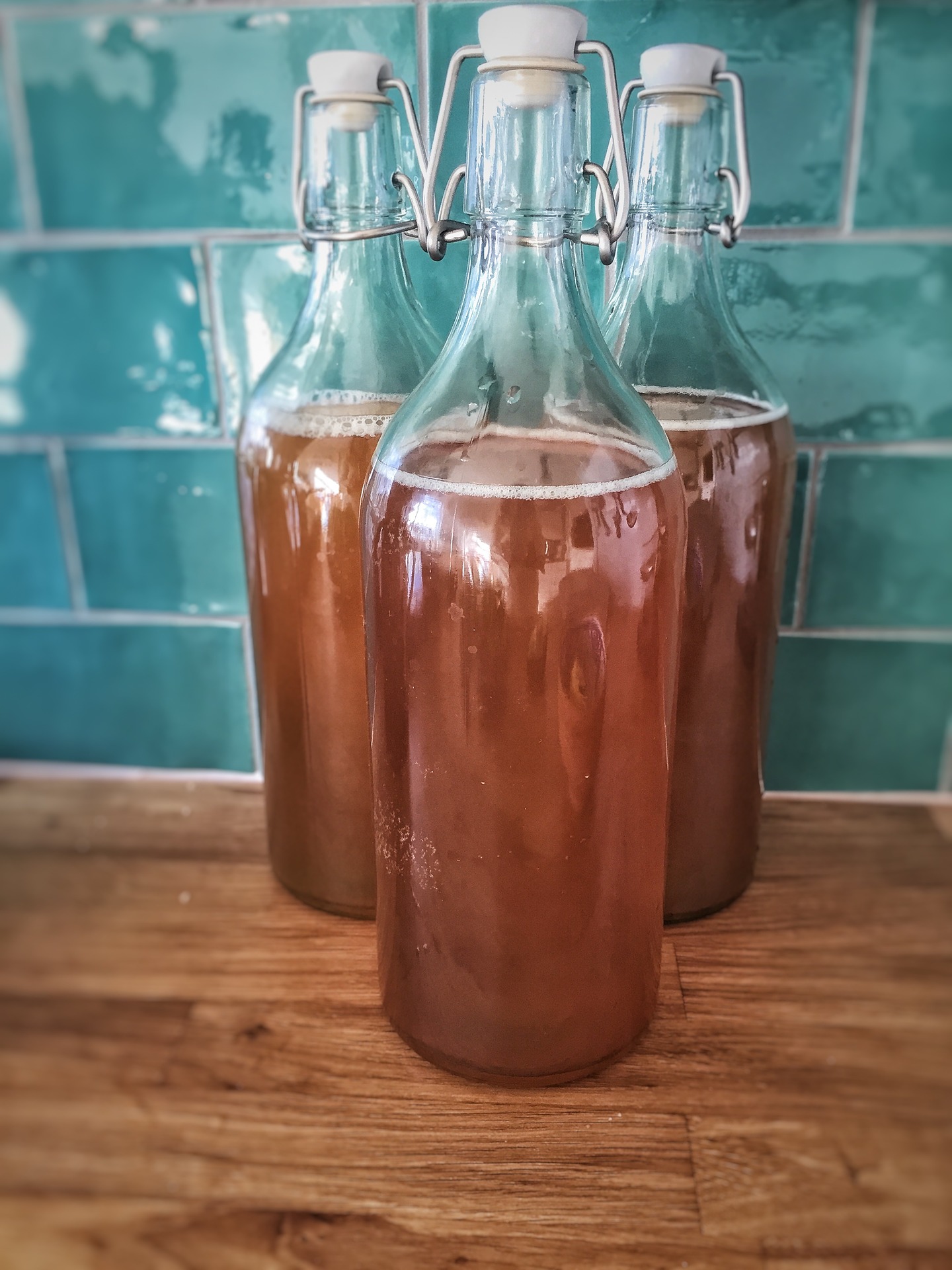 Three bottles of kombucha on a countertop