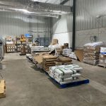 A warehouse room with palettes of bags of dry ingredients 