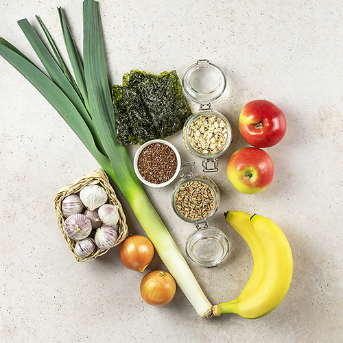 A group of fruit, veggies and grains in jars, top down, on a countertop 