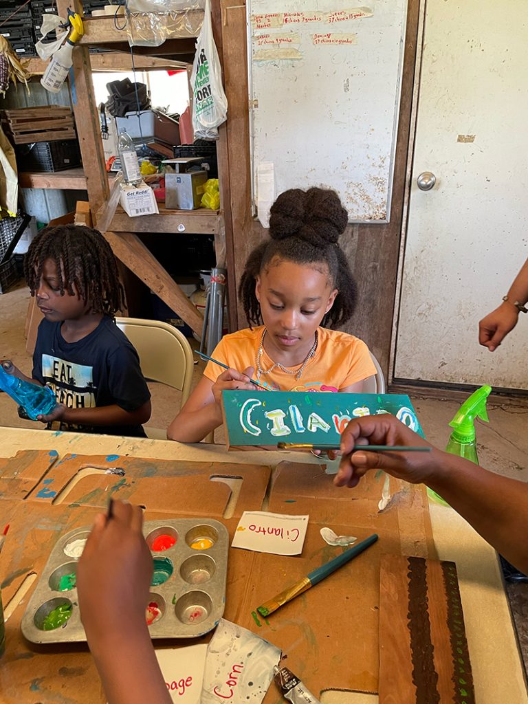 A couple of students painting signs for their garden